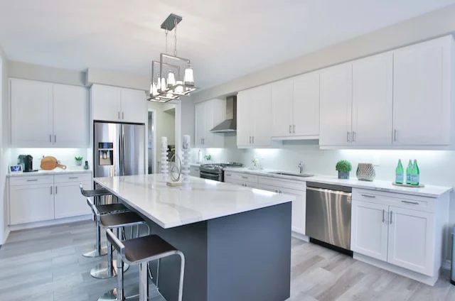 interior designer in chennai designed White cabinet and white marble table top Island Interior Design for the Kitchen